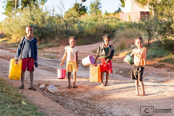 Enfants de corvée d'eau avant l'école à Ambatofinandrahana