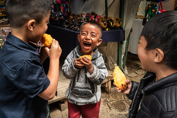 Au marché enfants mangeant des mangues