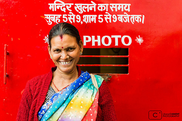 Femme posant devant le signe "No photo" d'un petit temple